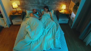 前视图年轻的夫妇谈话晚些时候晚<strong>上床上</strong>表蓝色的月亮光房间